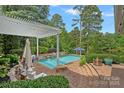 Beautiful in-ground pool and pergola, with outdoor seating, landscaping and a lake view at 1849 Still Water Ln, Indian Land, SC 29707