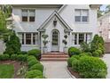 Elegant home entrance with arched doorway, brick steps, and lush, manicured landscaping at 206 Hillside Ave, Charlotte, NC 28209