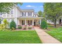 Charming two-story home with black shutters, a covered porch, and a well-manicured lawn at 2065 Gable Way Ln, Matthews, NC 28104