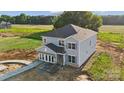 This is an aerial view of a two-story home with light gray siding, a dark gray roof, and a freshly poured walkway at 21071 Running Creek Dr # 12, Locust, NC 28097