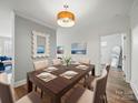 Elegant dining room featuring a wooden table, neutral chairs, and stylish modern light fixture at 2315 Selwyn Ave # F, Charlotte, NC 28207