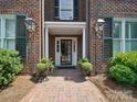 Inviting brick home entrance with decorative lanterns, potted plants, and a charming brick walkway at 2315 Selwyn Ave # F, Charlotte, NC 28207