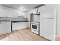 Bright kitchen featuring modern white appliances, ample cabinets and light wood floors at 2328 Danforth Ln, Charlotte, NC 28208
