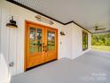 Inviting covered porch featuring stylish lighting and wood-framed glass entry doors at 2410 Charlotte Hwy, York, SC 29745