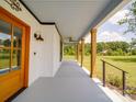 Expansive covered front porch with wood beams overlooks a beautifully landscaped yard at 2410 Charlotte Hwy, York, SC 29745