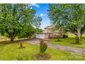 Beautiful home exterior with lush green lawn, mature trees, and a convenient two-car garage and long drive at 296 Hicks Creek Rd, Troutman, NC 28166