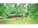 Exterior shot of a brick home with a sprawling yard surrounded by tall, mature trees at 3158 Salisbury Hwy, Statesville, NC 28677