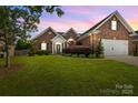 Charming brick home featuring a manicured lawn, attached garage, and inviting front entrance at 3419 Brickyard Ln, Midland, NC 28107