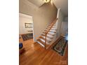 Bright foyer features hardwood floors and a staircase with wooden banister at 390 Robinson Rd, Mooresville, NC 28117