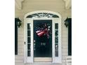 Charming home entrance with an eye-catching American flag wreath and decorative sidelights at 390 Robinson Rd, Mooresville, NC 28117