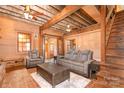 Inviting living room boasts exposed beam ceiling, wood paneled walls, comfortable seating, and staircase to upper level at 417 Phifer Rd, Kings Mountain, NC 28086