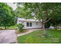 Inviting home with white siding, a metal roof, and mature trees, set back from the road at 535 Norman Fair Ave, Lincolnton, NC 28092