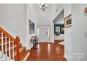 Bright foyer with hardwood floors, a staircase, and a stylish chandelier creating a welcoming entrance at 6004 Trailwater Rd, Charlotte, NC 28278