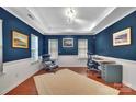 Comfortable home office with rich blue walls, white trim, and hardwood floors for a productive workspace at 6004 Trailwater Rd, Charlotte, NC 28278