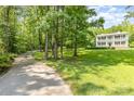 Picturesque home nestled in a wooded setting with a lush green lawn and a long driveway at 704 Little Creek Dr, Kings Mountain, NC 28086