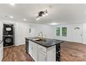 A modern kitchen featuring stainless appliances, sleek countertops, a geometric black island, plus laundry at 704 W Border St, Dallas, NC 28034
