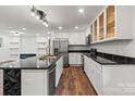 A modern kitchen featuring stainless appliances, sleek countertops, a geometric black island, and plenty of cabinet space at 704 W Border St, Dallas, NC 28034