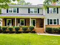 Inviting home featuring a classic brick porch, rocking chairs, and manicured landscaping at 734 Forestbrook Dr, Gastonia, NC 28056
