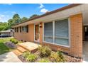Brick home with a covered entry, mature landscaping, and multi-pane windows at 888 Stowe Ln, Gastonia, NC 28056