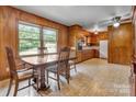 Vintage eat-in kitchen with wood-paneled walls, classic cabinets, and bright window at 888 Stowe Ln, Gastonia, NC 28056