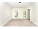 Neutral bedroom boasts large windows for natural light and soft carpeting at 9146 Austin Ridge Ln, Charlotte, NC 28214