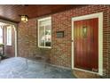 Inviting front porch features a wood door, lantern lighting, stone floor, and a cozy bench at 1021 Isleworth Ave, Charlotte, NC 28203