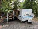 Prowler camper with awning extended, a golf cart, and outdoor seating at 103 Powder Horn Trl, Mount Gilead, NC 27306