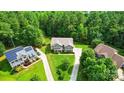 Expansive aerial view showcasing the home's lush green surroundings and long driveway, perfect for privacy at 110 St Sophia Ct, Mooresville, NC 28117