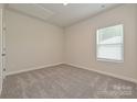 Bright bedroom features neutral carpet, a window with blinds, and a ceiling access panel at 1205 Morehead Dr, Salisbury, NC 28144