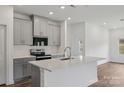 Open kitchen boasts gray cabinets, quartz countertops, a white tile backsplash, and stainless steel appliances at 1205 Morehead Dr, Salisbury, NC 28144