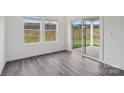 Bright living room features gray wood flooring, white trim, and sliding glass door to the backyard at 1205 Morehead Dr, Salisbury, NC 28144