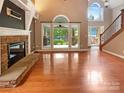 Open-concept living room with hardwood floors, fireplace, and natural light at 12092 Spinnaker Dr, Fort Mill, SC 29708