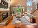 Bright living room featuring a fireplace, high ceilings, and views of the backyard at 12092 Spinnaker Dr, Fort Mill, SC 29708