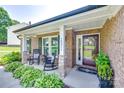 Inviting brick front porch with rocking chairs and meticulous landscaping at 12311 Bentcreek Ln, Matthews, NC 28105