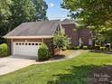 Side view of a brick home with an attached two-car garage and well-kept lawn at 150 Pinnacle Shores Dr, Mooresville, NC 28117