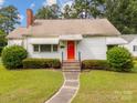 Inviting home with a red door, manicured bushes, and a walkway leading to the entrance at 216 Hillcrest Pl, Salisbury, NC 28144