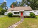 A well-kept home with a red front door, lush lawn, and a detached garage at 216 Hillcrest Pl, Salisbury, NC 28144
