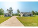 Long driveway to a well-kept home and detached garage surrounded by lush greenery and mature trees at 2737 Bobcat Rd, Heath Springs, SC 29058