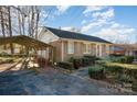 A brick home with a carport boasts a tidy landscape, complemented by green shutters and a well-kept driveway at 2809 Markland Dr, Charlotte, NC 28208