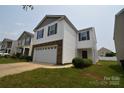 Charming two-story home featuring a stone facade, white siding, and a two-car garage at 3014 Green Apple Dr, Dallas, NC 28034