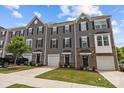 View of townhomes with gray siding, black shutters, and manicured lawns and driveways at 3108 Beeler Ln, Charlotte, NC 28208
