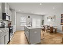 Open kitchen with a quartz island, bar stools, and a dining area in a bright, modern space at 3108 Beeler Ln, Charlotte, NC 28208