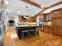 Spacious kitchen featuring wood beams, a large island with seating, and modern stainless steel appliances at 315 Mountainview Dr, Charlotte, NC 28270