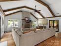 Living room featuring wood beams, a stone fireplace, a large sectional sofa, and hardwood floors at 315 Mountainview Dr, Charlotte, NC 28270