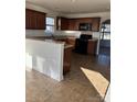 Well-lit kitchen with stainless steel appliances, granite countertops, and dark wood cabinets at 3244 Oulten Sw St, Concord, NC 28027