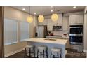 Modern kitchen with stainless steel appliances, gray cabinets, white countertops, and pendant lighting at 332 Cranford Dr, Pineville, NC 28134