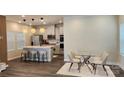 Open-concept kitchen with island seating flowing into dining area with glass table at 332 Cranford Dr, Pineville, NC 28134
