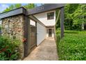 Inviting home entrance with stone details, lush greenery, and a walkway leading to the front door at 3737 Winding Creek Ln, Charlotte, NC 28226