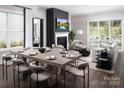 Spacious open-concept living and dining area with hardwood floors, modern fireplace, large windows, and an outdoor patio beyond at 4146 Eastover Glen Rd # 0322, Charlotte, NC 28269