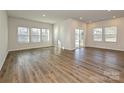 Bright living room with wood-look floors, large windows, and a sliding glass door to the yard at 450 Bent Burr Crk, York, SC 29745
